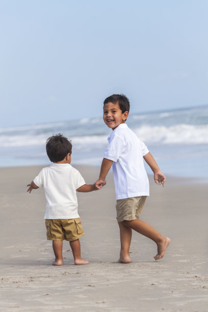 两个小男孩兄弟在海滩上玩耍图片下载