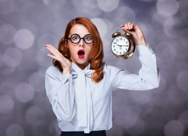 有时钟的红发女人。图片下载