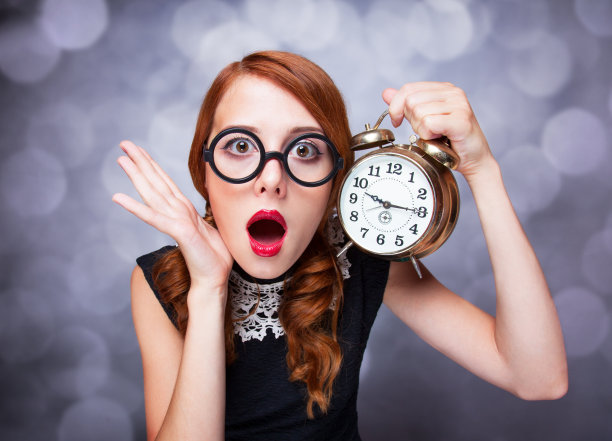 有时钟的红发女人。图片下载