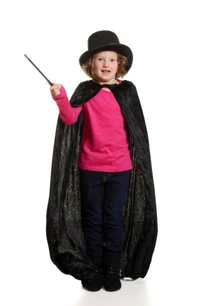 惊讶的女孩打扮成魔术师动作模糊的魔杖图片下载