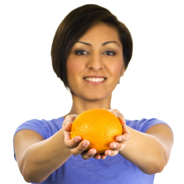 微笑的年轻民族妇女拿着一个橙子。图片下载
