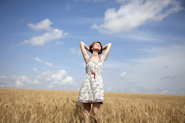 年轻美丽的姑娘在麦田里。图片下载