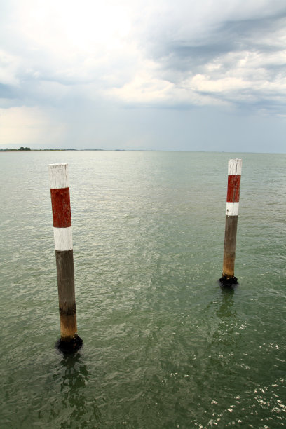 海水中间的两根木制信号柱图片下载