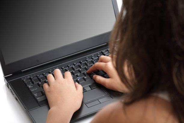 一个坐在笔记本电脑前的女人的后视图图片下载