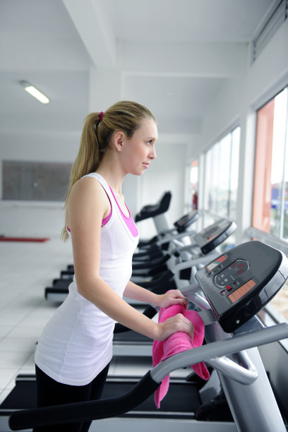 在健身房跑步机上跑步的女人图片下载