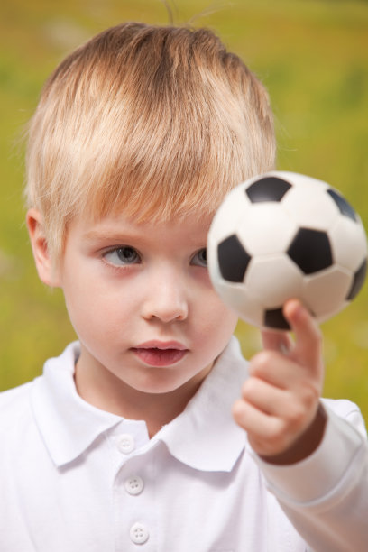 可爱的男孩在户外拿着足球图片下载