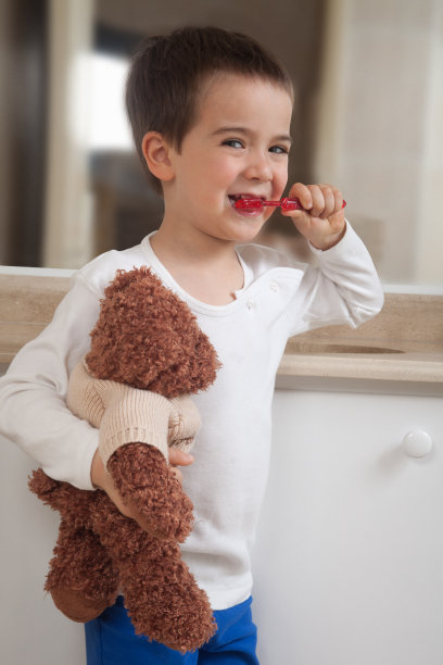 男孩和泰迪熊一起刷牙图片下载