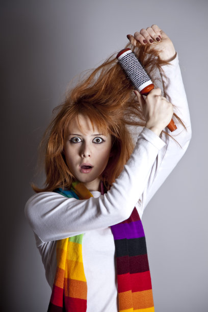 悲伤的红头发女孩梳着梳子图片下载