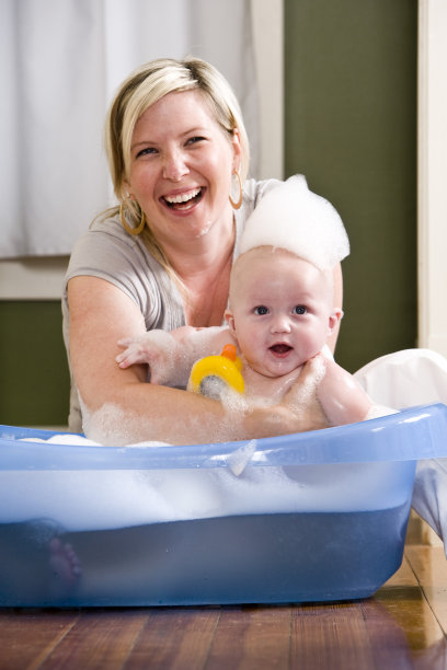 快乐的妈妈给可爱的宝宝洗澡图片下载