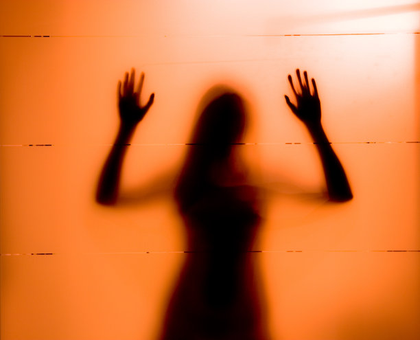 在磨砂玻璃后面的年轻女人图片下载