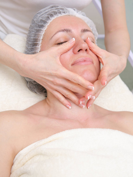 年轻女子在水疗中心做面部按摩图片下载