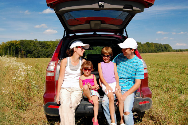 一家四口在他们的车旁边度假图片下载