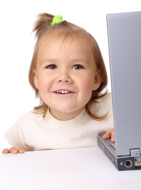 可爱的小女孩正从她的笔记本电脑向外看图片下载