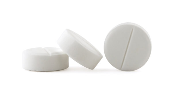 三片白色阿司匹林，一片侧着，另一片斜着图片下载