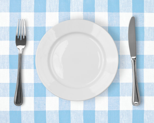 刀，白盘子和叉子放在蓝格子桌布上图片下载