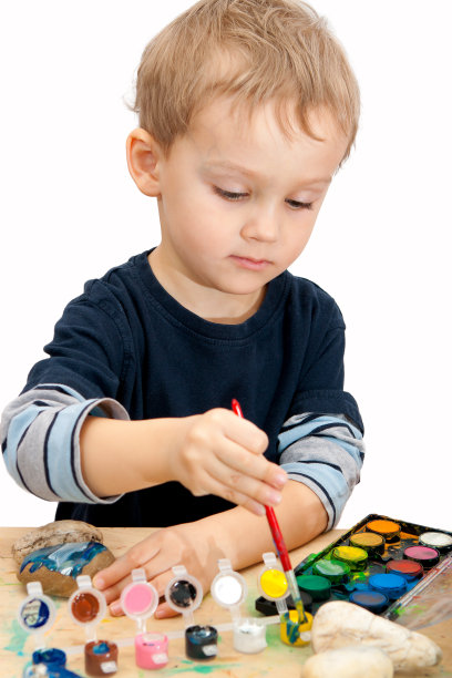 小男孩用水彩画石头图片下载