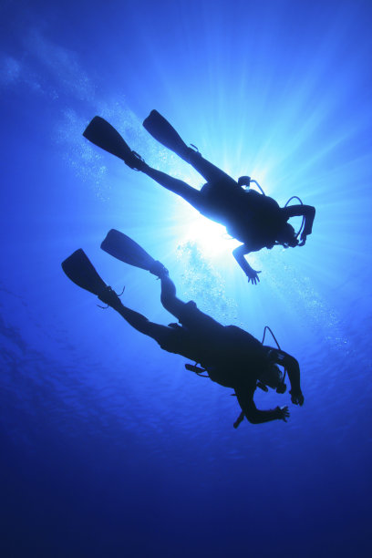 两个人带着水肺潜水，在阳光照射下图片下载