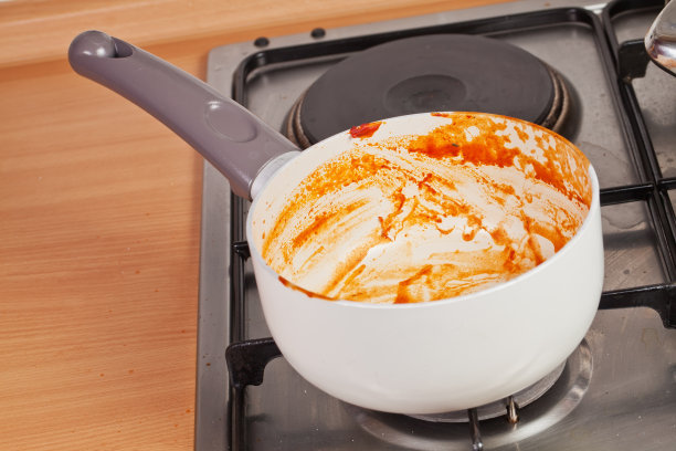 炉子上的脏平底锅里还有残留的番茄汤图片下载