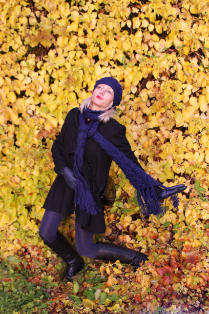金发女郎在秋天的黄叶中跳舞图片下载