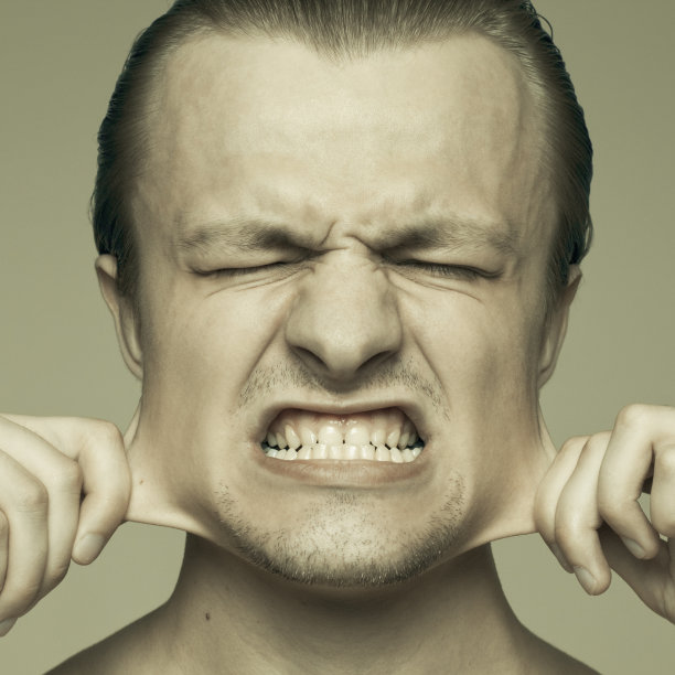 一个年轻人的肖像，他的脸颊在伸展图片下载