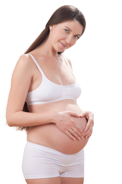迷人的孕妇在内衣摆姿势的白色背景图片下载