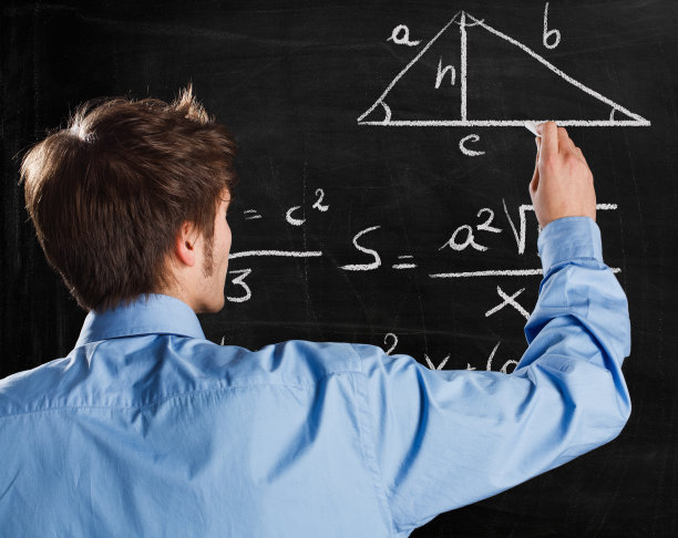 穿蓝衬衫的年轻人在黑板上做几何题图片下载