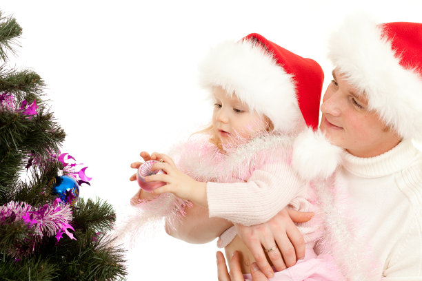 父亲帮助女儿装饰圣诞树图片下载