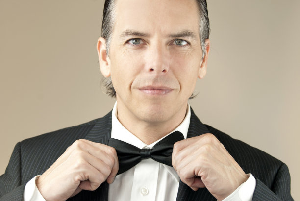 自信的男士用双手调整领结图片下载