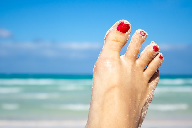 晒黑的女人的脚与热带海滩的背景图片下载