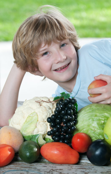 微笑健康的男孩拿着一个苹果，水果和蔬菜图片下载