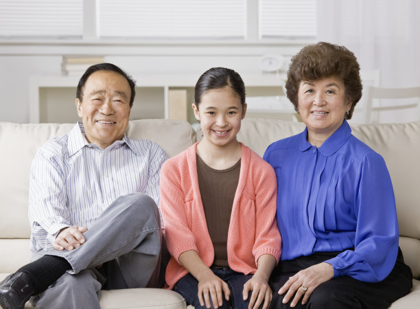 快乐的奶奶，爷爷和孙女在客厅的沙发上休息图片下载