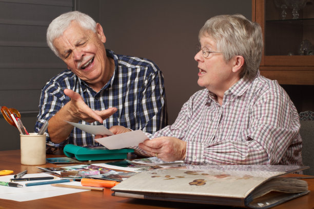 老夫妇为剪贴簿选择照片图片下载