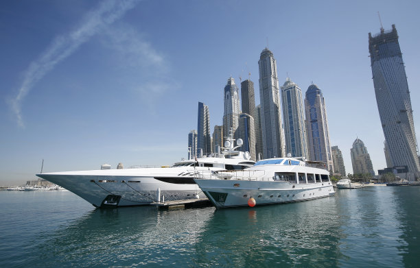 现代住宅楼背景下的迪拜超级游艇图片下载