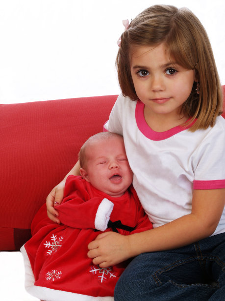 穿着红衣服的年轻女孩和婴儿坐在一起图片下载