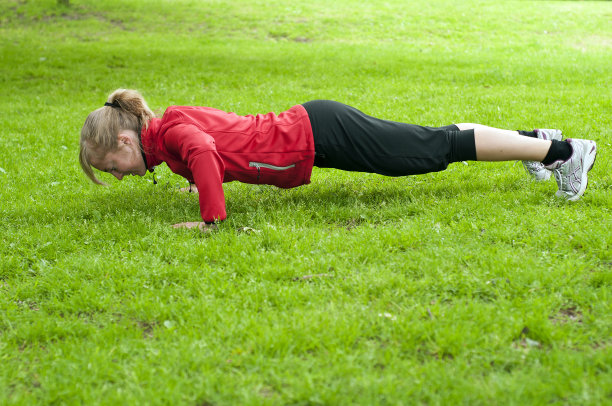在草坪上做俯卧撑的女孩图片下载