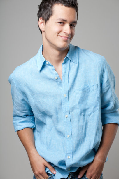 穿着蓝色衬衫摆姿势的英俊男子。图片下载