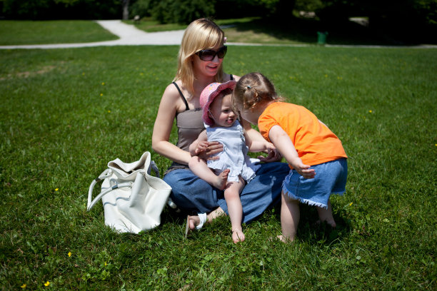 年轻的母亲在公园里和她的女儿们玩耍图片下载