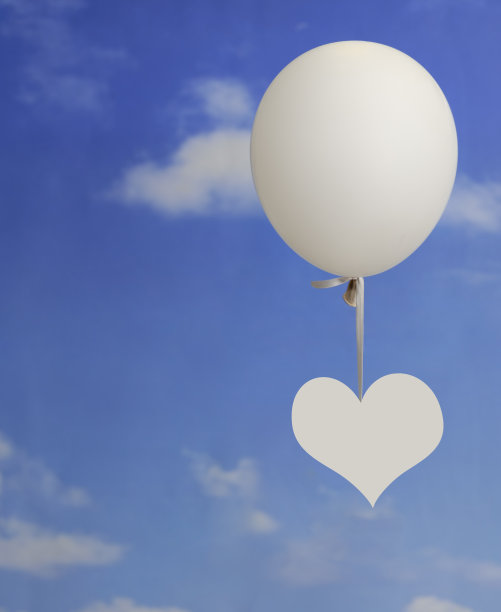 爱情概念:白色的心形挂在气球上图片下载