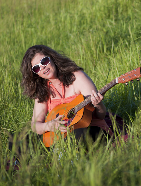 单身女子在户外唱歌和弹吉他图片下载