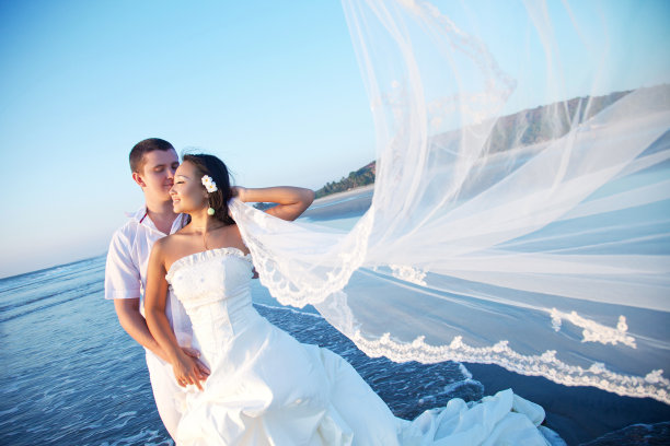 日落时分，新婚夫妇在海滩上图片下载