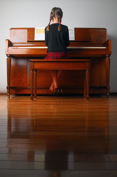 一个扎着辫子的女孩在学弹钢琴图片下载