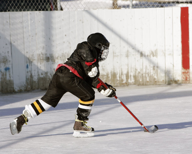 全副武装在池塘上打冰球的曲棍球运动员图片下载