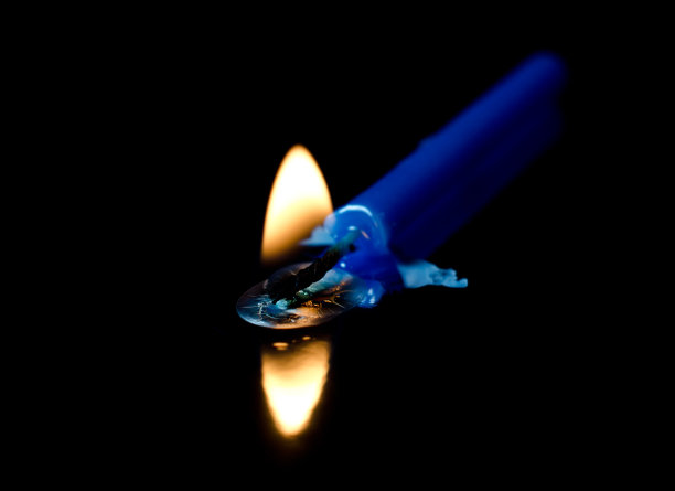 燃烧的蓝色蜡烛在一个黑色的背景图片下载