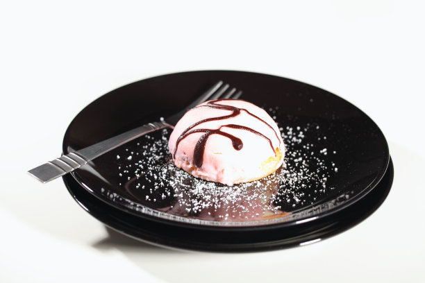 黑色盘子上的粉色奶油蛋糕图片下载