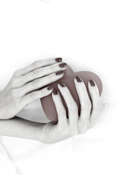 美丽女人的双手捧着一颗大大的红心图片下载