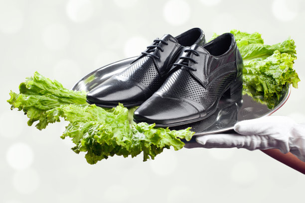 侍者的手牵着一双男鞋图片下载