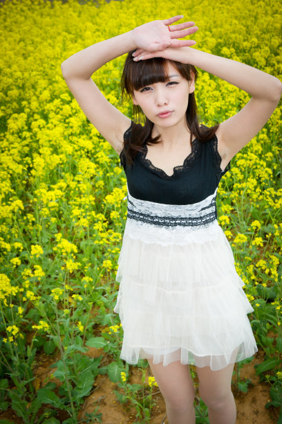 美丽的女孩看着油菜花图片下载