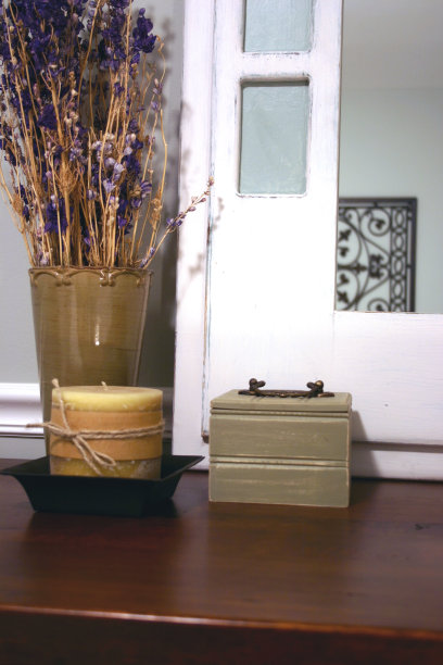 梳妆台上有镜子、蜡烛、花瓶和盒子。图片下载