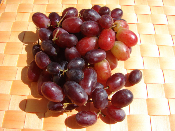 橙色背景上的黑葡萄图片下载