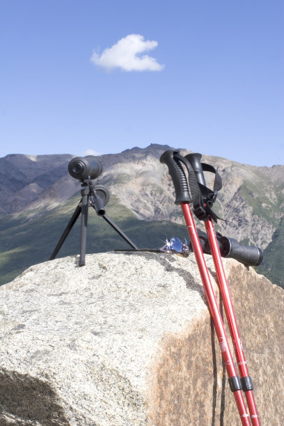 徒步旅行的棍棒和观察范围的岩石。图片下载